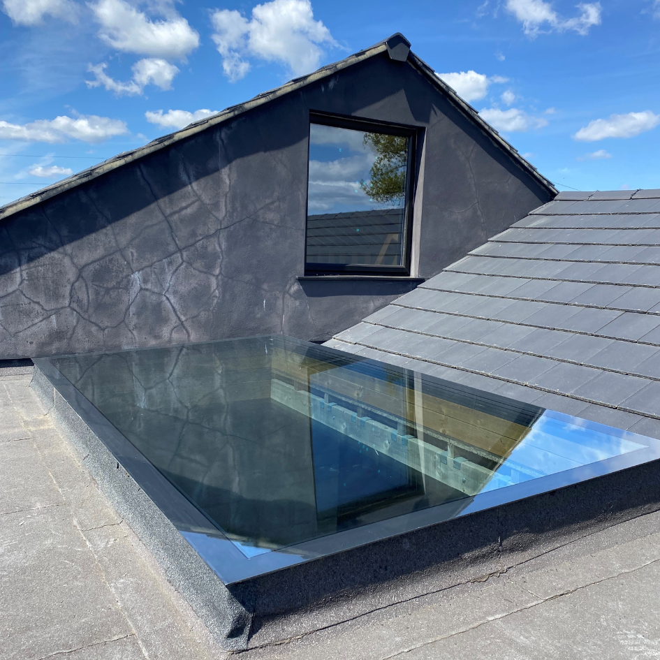 A modern roof featuring a glass skylight rooflight.